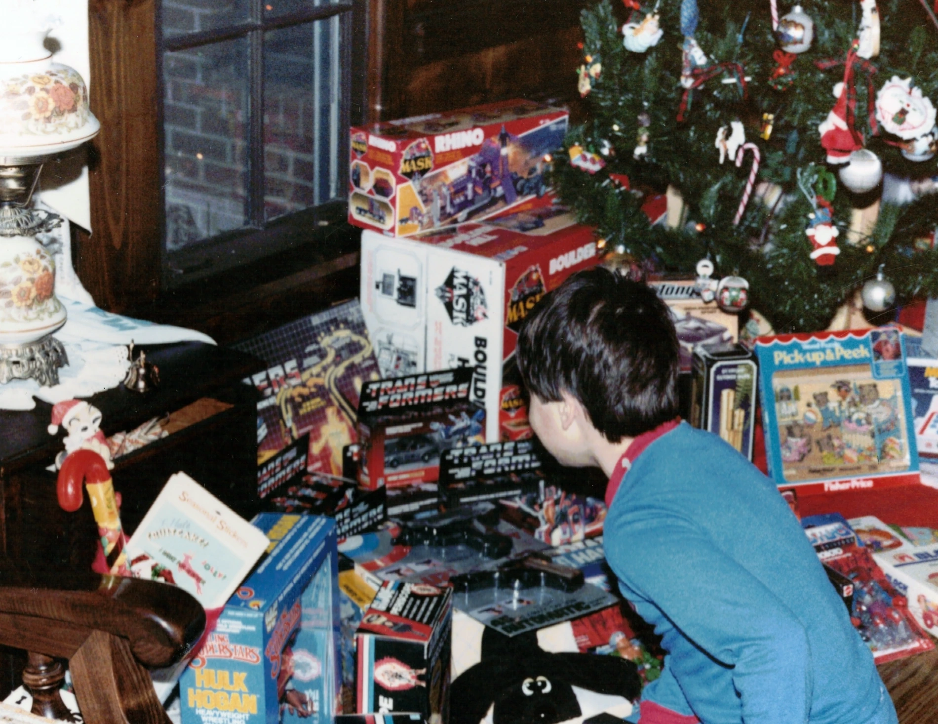 Christmas 1985 family photo with a child surrounded by classic 1980s toys beneath the tree