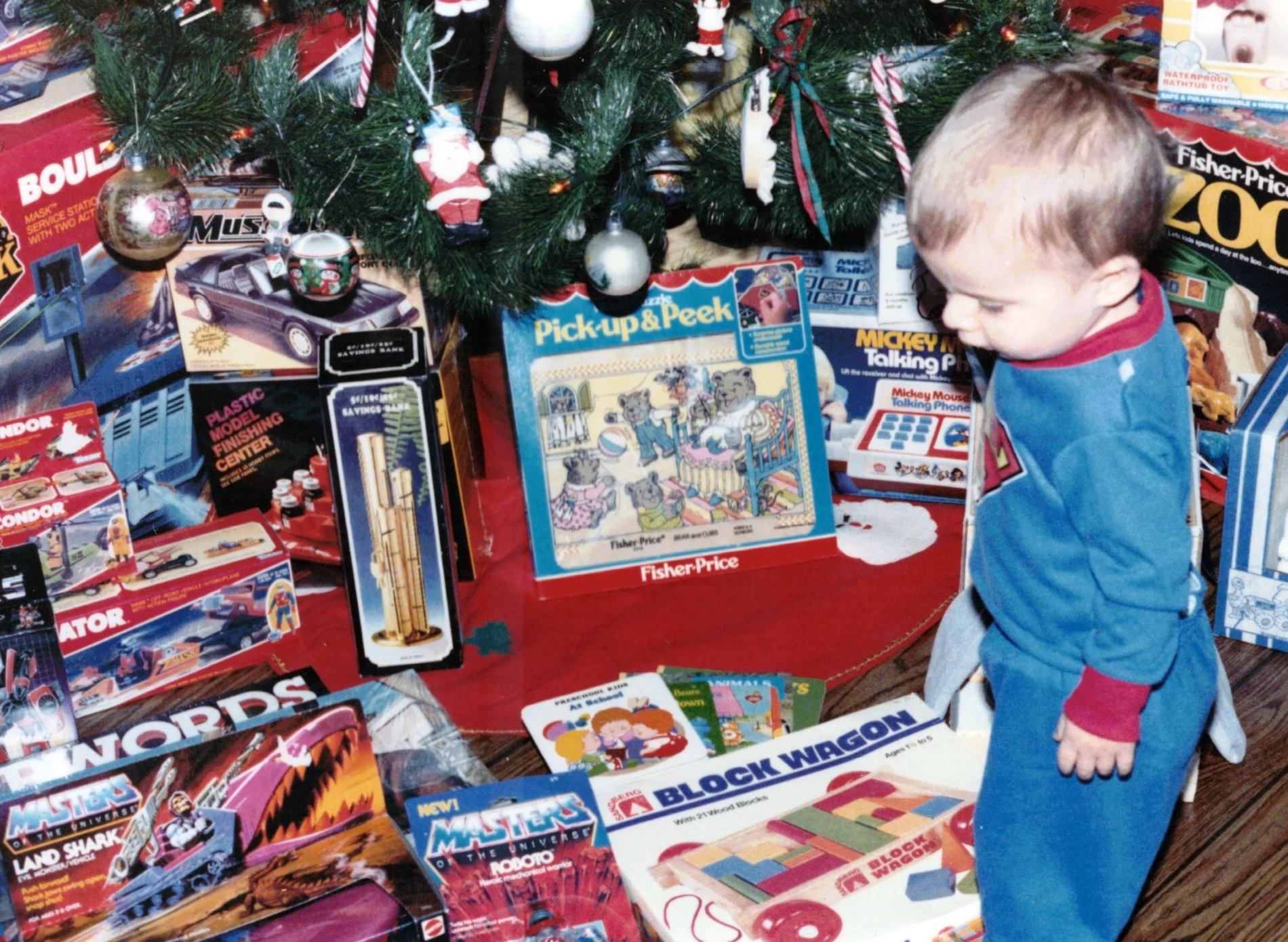 Christmas 1985 family photo with classic 1980s toys, games, vehicles and action figures beneath the tree